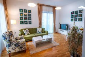 布德瓦Luxury Budva Center Apartments的客厅配有绿色沙发和茶几