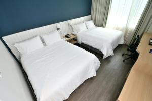 亚松森Holiday Inn Express Asuncion Aviadores , an IHG Hotel的酒店客房,配有两张带白色床单的床