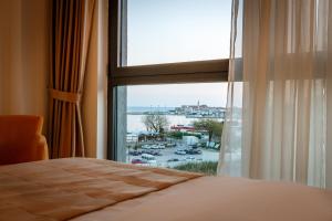 布德瓦Luxury Budva Center Apartments的一间卧室设有窗户,享有海港景色