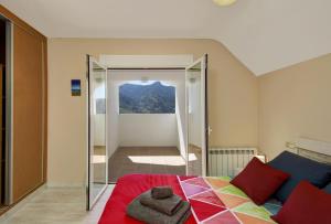 圭哈尔谢拉Ático con chimenea en Sierra Nevada-Güejar Sierra的一间卧室设有一张床和一个享有美景的玻璃门