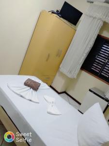 容迪亚伊Hotel Central Rosário的一间设有白色床和黄色门的房间