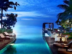 巴厘巴板The Malibu Suites Balikpapan by Sissae Living的游泳池,晚上可欣赏到海景