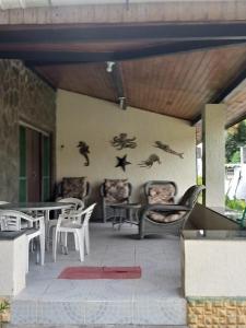 伊塔帕里卡Casa Ilha de Itaparica的墙上设有带桌椅的庭院和鸟类