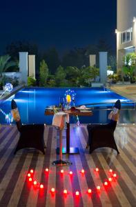 邦加槟港Swiss-Belhotel Pangkalpinang的晚上在庭院里摆放着桌椅