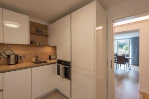 萨尔茨堡Apartment Villa Leopoldskron的一间厨房,配有白色橱柜和一间餐厅