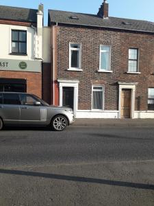 贝尔法斯特Titanic Sailortown Belfast City Centre townhouse的停在街道边的银色豪华轿车
