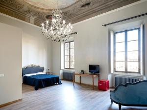 佛罗伦萨B&B Stupido Hotel的一间卧室配有蓝色的床和吊灯。