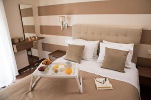 雅典AT.thea ATHENS BOUTIQUE APARTMENTS的一间酒店客房,配有一张床铺,上面装有水果盘