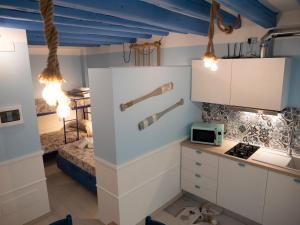 基奥贾Appartamenti Vale Mare的一间厨房,配有白色的橱柜和一张位于客房内的床