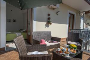 阿杰罗拉Appartamenti Aria di Verde的庭院配有桌椅和遮阳伞。