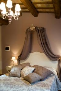 Serrungarina卡萨狄米旅馆的卧室配有一张挂在墙上的带窗帘的床