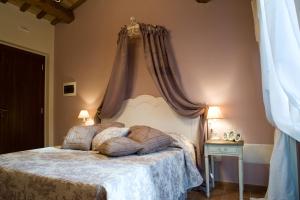 Serrungarina卡萨狄米旅馆的一间卧室配有一张带天蓬的大床