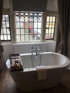 威灵堡雌鹿酒店的带窗户的客房内的白色浴缸