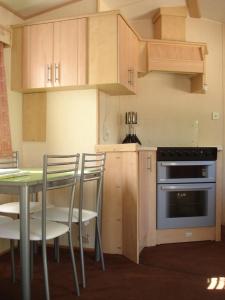 贝纳哈拉菲尼扎普拉亚野营山谷酒店的厨房配有桌椅和烤箱。