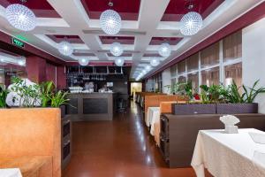 HatneTerra Nova Sport&Spa Hotel的用餐室配有桌椅和灯光