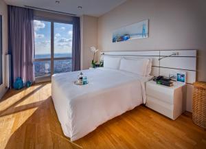 伊斯坦布尔伊斯坦布尔辉盛坊国际公寓的卧室设有一张大白色的床和大窗户