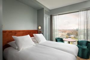 阿姆斯特丹Olympic Hotel的酒店客房设有一张床和一个大窗户