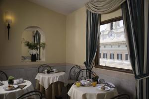 罗马Colonna Palace Hotel的一间设有两张桌子和窗户的用餐室