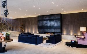 施万高AMERON Neuschwanstein Alpsee Resort & Spa的大堂设有2张蓝色的沙发和壁炉