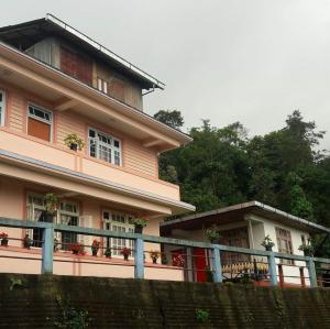 NamchiVAMOOSE SALOM NAMCHEBAZAR的粉红色的房子,前面有栅栏