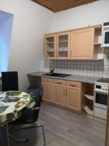 诺德豪森Zimmer的厨房配有木制橱柜、桌子和桌子。