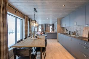 科威费耶尔Varden Fjellandsby Kvitfjell的厨房以及带木桌的用餐室。