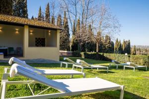 佛罗伦萨艾盖浦艺术别墅酒店的一组躺椅坐在草地上