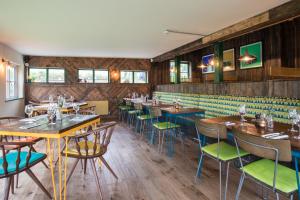 牛顿阿伯特Dartmoor Halfway Inn的餐厅拥有木墙和桌椅