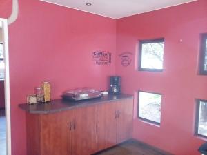 米德尔堡Woodpecker Guesthouse Middelburg Mpumalanga的带红色墙壁的客房,设有带柜台的厨房
