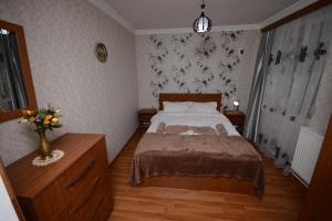 博尔若米拉兹卡公寓的一间卧室,配有一张床和花瓶