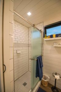 韦科Elegant Container Tiny House Yellow & Blue的浴室里设有玻璃门淋浴