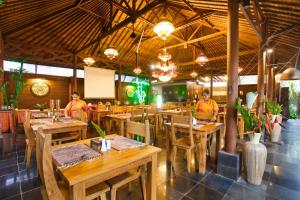 乌布Ubud Raya Shala的一间设有木桌椅的餐厅,可容纳4人
