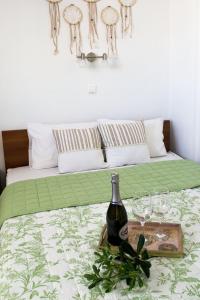 雅典INSPIRATION Guestroom with Amazing Roof Garden的床上有一瓶葡萄酒和眼镜
