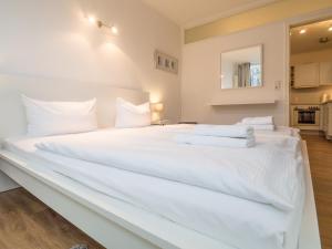 萨斯尼茨Appartement Nr 7 im Sonnenbad的一张白色大床,配有白色床单和枕头