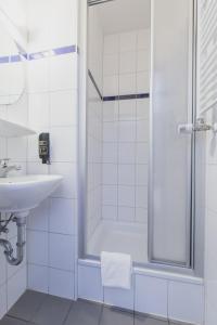 纽伦堡A&O纽伦堡火车总站酒店的带淋浴和盥洗盆的白色浴室