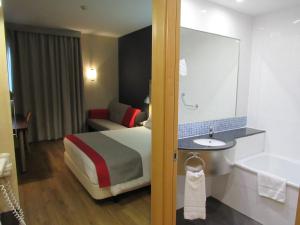 马拉加Holiday Inn Express Málaga Airport, an IHG Hotel的酒店客房配有一张床和浴缸。
