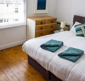 帕兹托Drang house all rooms have stairs的一间卧室配有一张带两张绿毛巾的床