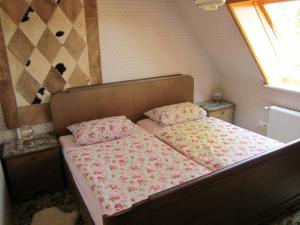 维岑多夫Haus Annegret的一间卧室配有一张带粉色床单的床和一扇窗户。