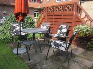 维岑多夫Haus Annegret的一组椅子和一张桌子及一把伞