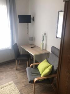 布伦Landgasthaus Jägerhof的客厅配有桌子、椅子和书桌