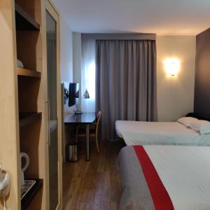 马拉加Holiday Inn Express Málaga Airport, an IHG Hotel的酒店客房配有两张床和一张书桌