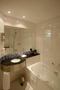 马拉加Holiday Inn Express Málaga Airport, an IHG Hotel的带浴缸、水槽和淋浴的浴室