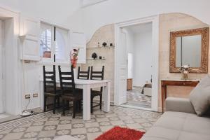 布林迪西Appartamenti Luxury Greco的用餐室以及带桌椅的起居室。