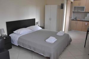马科普隆AVR Airport Deluxe Suites 4的一间卧室配有一张大床和两条毛巾