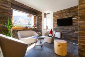 安达洛Residence Mille Montagne的客厅配有沙发、椅子和电视