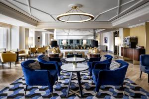 多伦多Fairmont Royal York Gold Experience的酒店大堂设有蓝色的椅子和桌子。