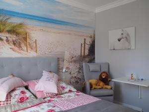 塞巴特阿尔贝克Kaisers Eck Ferienwohnung的卧室配有一张床,海滩画