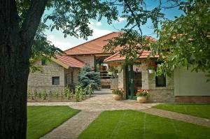 采格莱德BÉNI family wine farm的砖屋,有绿色草地的院子