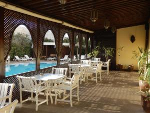 索维拉里亚德扎赫拉酒店的一个带白色桌椅的庭院,毗邻游泳池