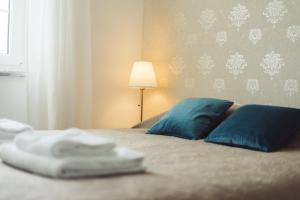 佩尼契YEY Atouguia da Baleia的一间卧室配有一张带蓝色枕头和一盏灯的床。